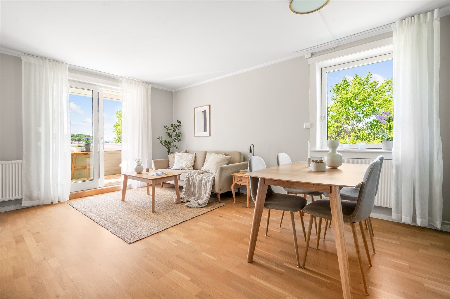 Her får du en innbydende og romslig stue med store vindusflater som slipper inn rikelig med naturlig lys, samt et hyggelig og grønt utsyn.
