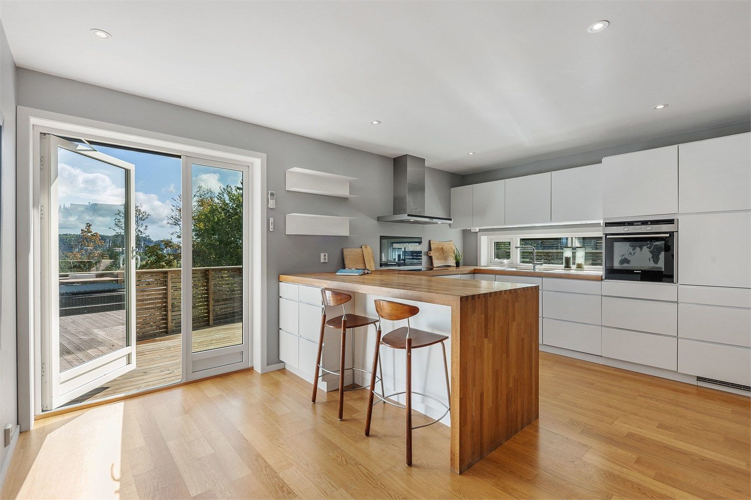 En solid benkeplate i eik og integrerte hvitevarer understreker den gjennomførte stilen, som forsterkes med den solide benkeplaten i eik.