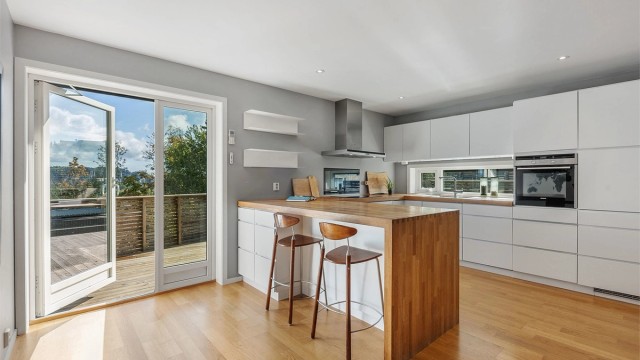 En solid benkeplate i eik og integrerte hvitevarer understreker den gjennomførte stilen, som forsterkes med den solide benkeplaten i eik.