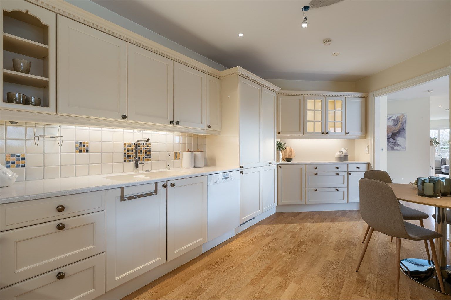 Kjøkkeninnredning er med profilerte fronter fra Huseby. Benkeplaten er i Corian med nedsenket oppvaskkum.