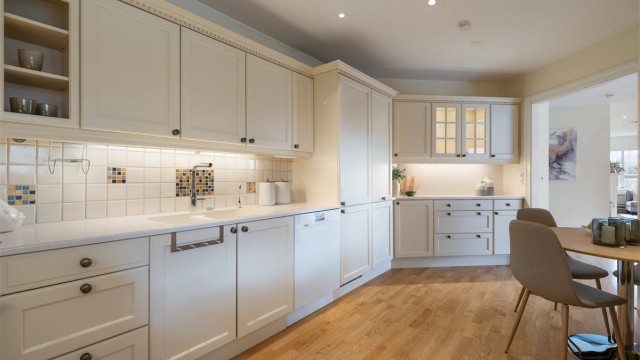 Kjøkkeninnredning er med profilerte fronter fra Huseby. Benkeplaten er i Corian med nedsenket oppvaskkum.