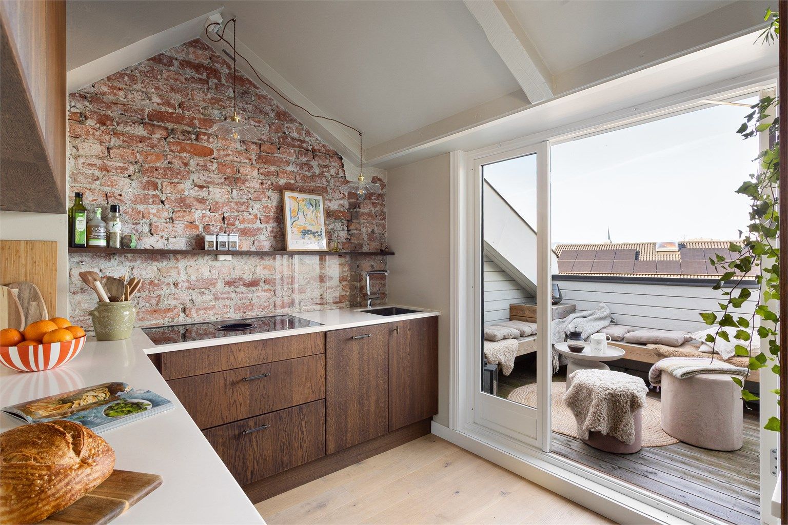 Kjøkkenet har en eksponert teglsteinsvegg som gir rommet karakter og lar et lite ekko av loftets opprinnelige historie fra 1888 leve videre