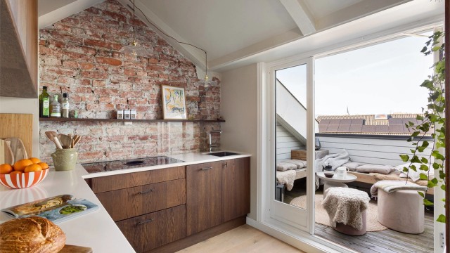 Kjøkkenet har en eksponert teglsteinsvegg som gir rommet karakter og lar et lite ekko av loftets opprinnelige historie fra 1888 leve videre