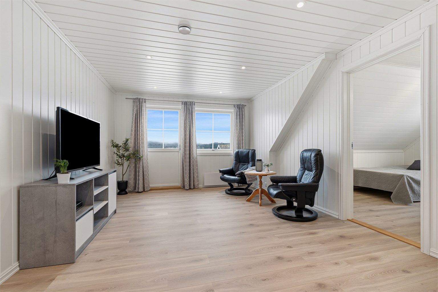 Romslig loftsstue med utgang til balkong med fin utsikt og eiendommens beste solforhold