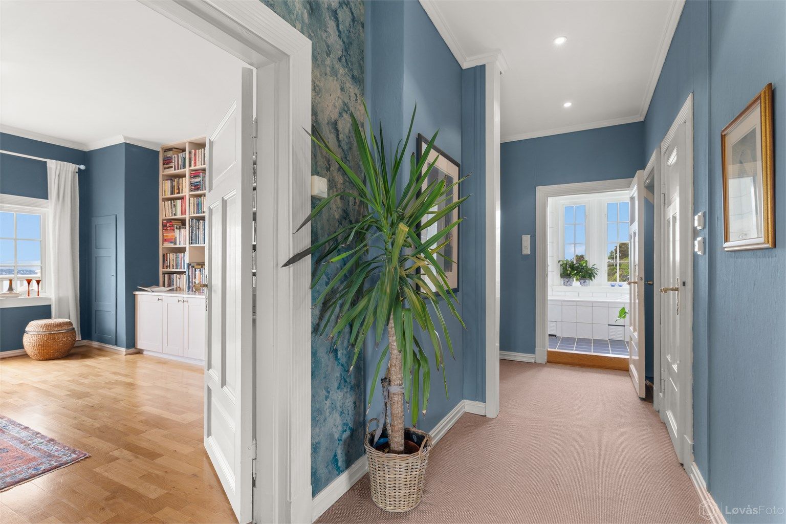 Trappegang med gulvteppe og downlights i himling. Gang ved baktrappen har tilliggende bod