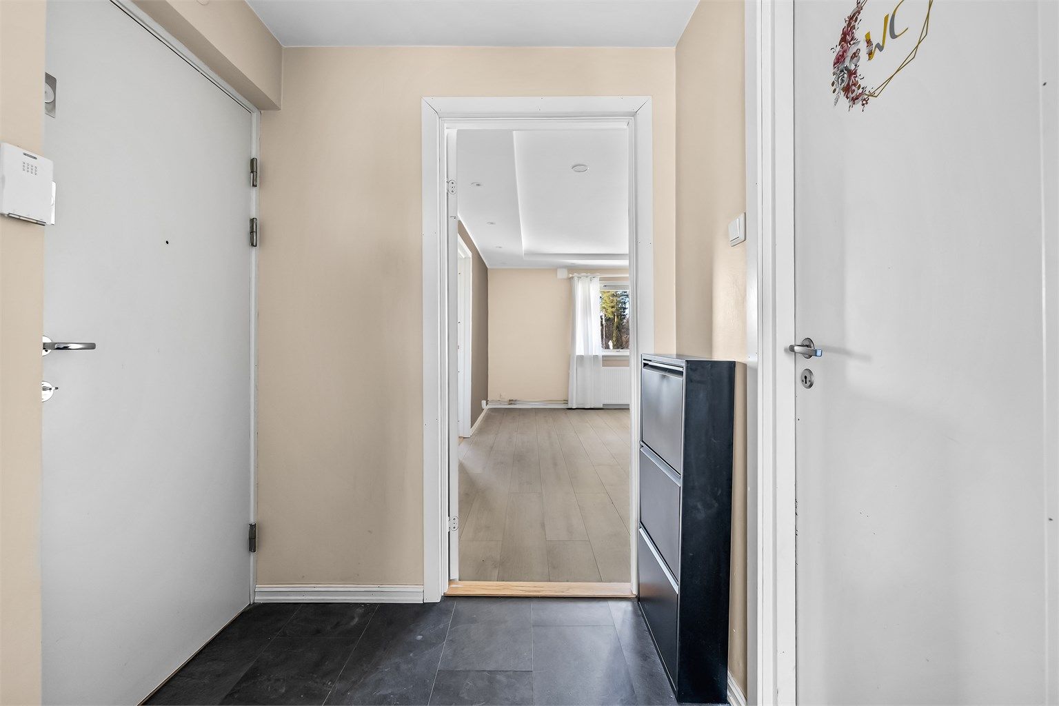 Entreen er lys med malte flater på vegger, og det er adkomst til stue, kjøkken og bad fra entré.