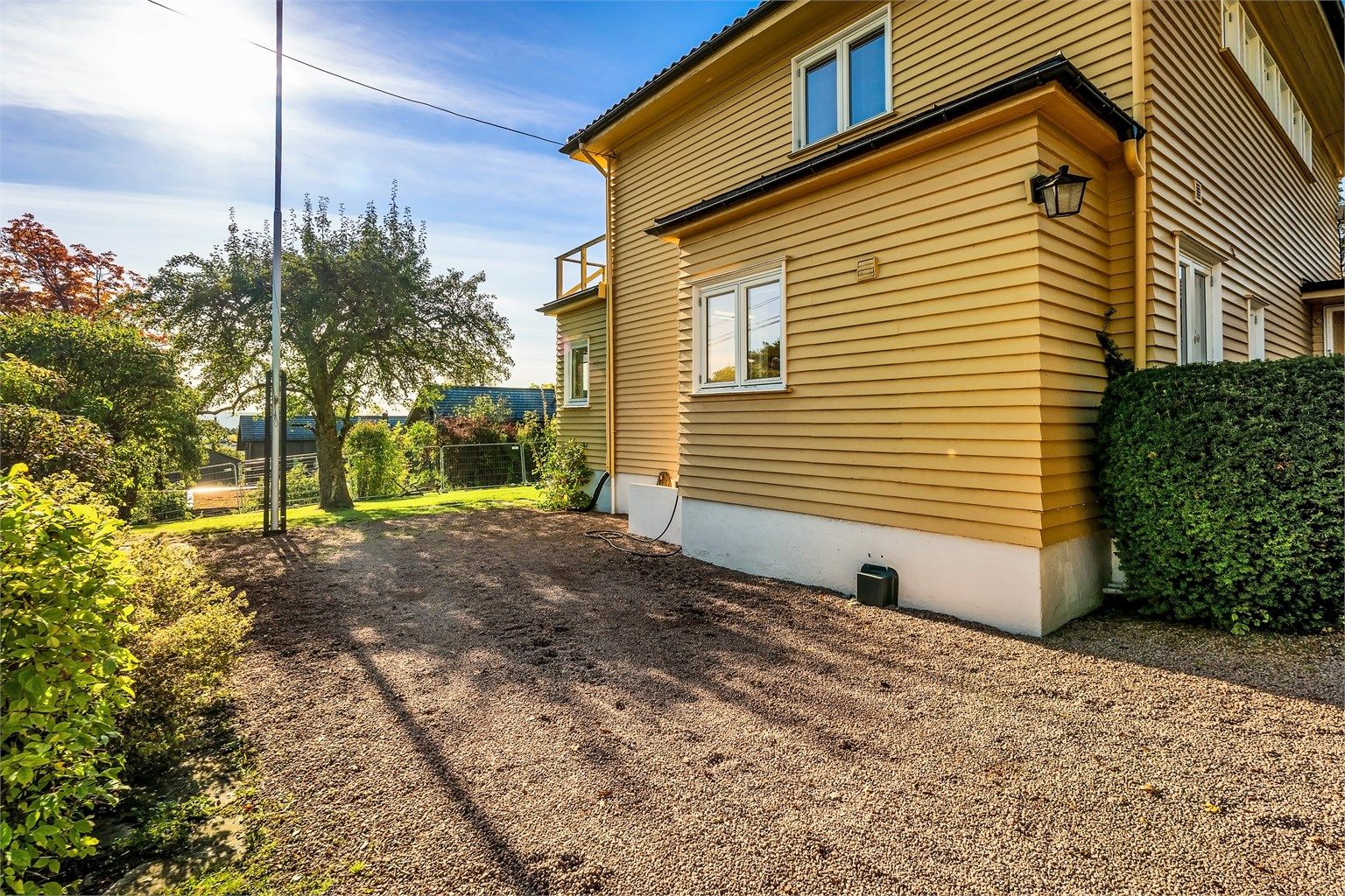 Boligen har gruslagt gårdsplass og garasje