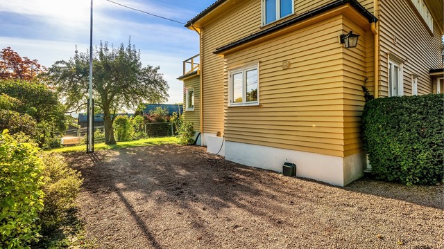 Boligen har gruslagt gårdsplass og garasje