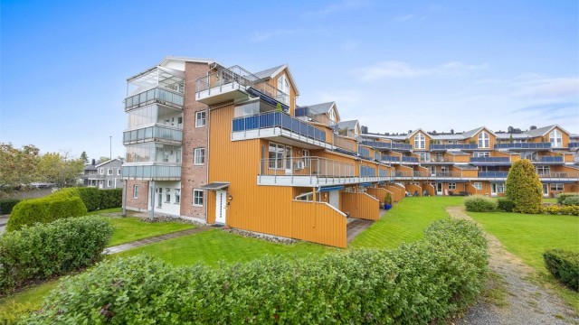 Terrassert leilighetsbygg med felles parkanlegg og grønne plenarealer.