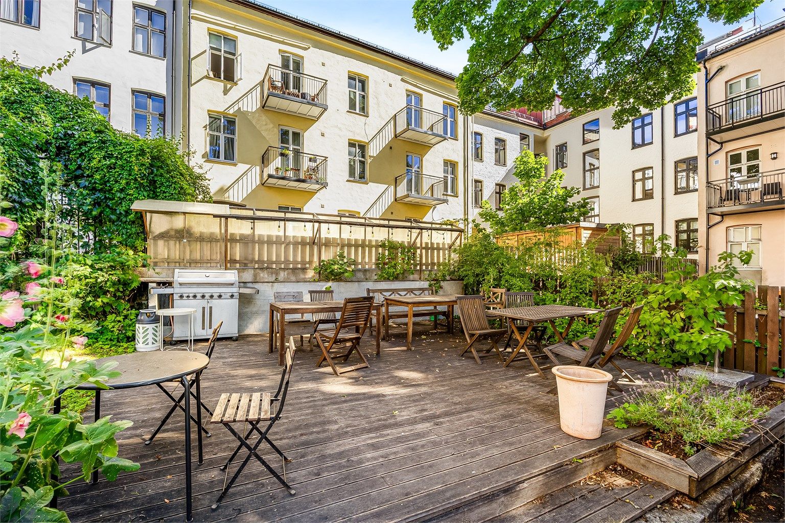 Hyggelig og skjermet felles uteområde med sittegrupper og grill, en grønn oase midt i byen.
