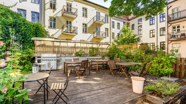 Hyggelig og skjermet felles uteområde med sittegrupper og grill, en grønn oase midt i byen.