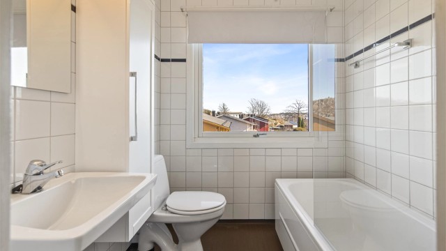 Badet i andre etasje har belegg på gulv, flislagte vegger og er utstyrt med badekar.
