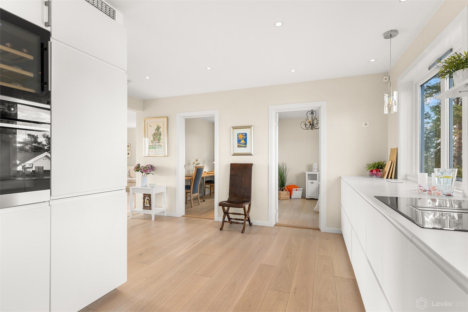 Den delvis åpne løsningen mellom kjøkken og stue skaper en sosial og luftig atmosfære.