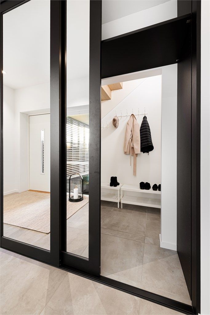 Store skyvedørsfronter med speilfronter. Under trappa er det et praktisk garderoberom 