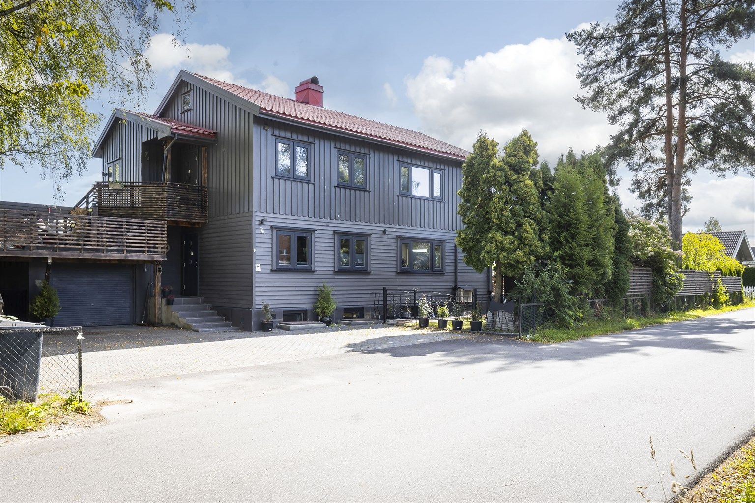 Fasade mot veien. Boligen har tilknyttet garasje på 18 kvm (BRA-e). Det er kort vei til skoler og barnehager og det er gode bussforbindelser i området.