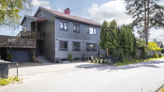 Fasade mot veien. Boligen har tilknyttet garasje på 18 kvm (BRA-e). Det er kort vei til skoler og barnehager og det er gode bussforbindelser i området.