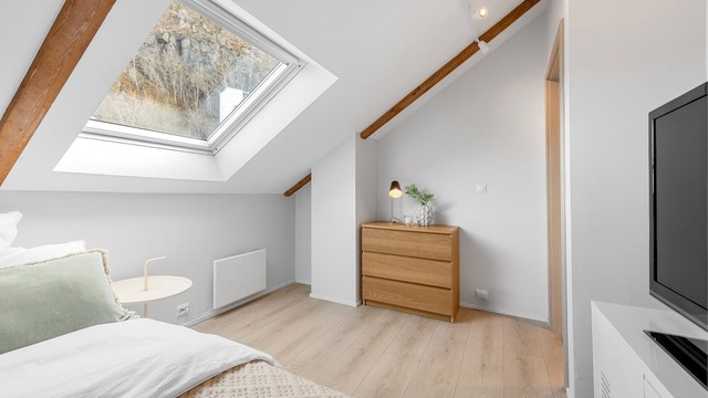 Soverommet har malte flater og laminat på gulvet, i tråd med resten av leiligheten.