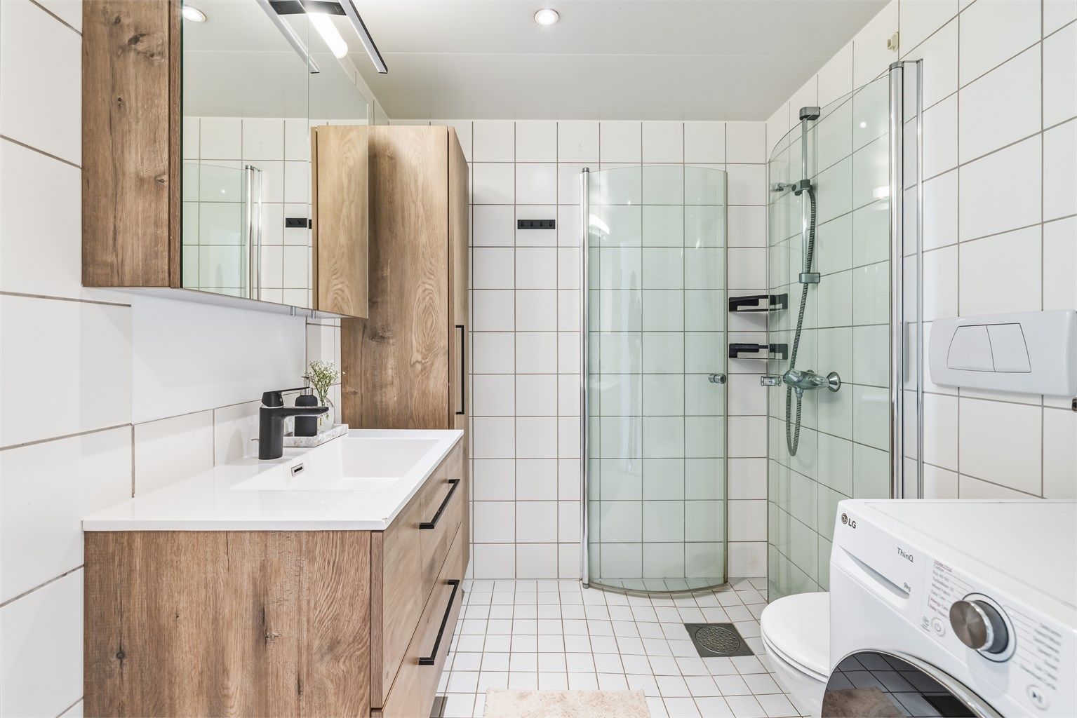 Prefabrikkert baderom fra byggeår med fliser på vegger og gulv. Det er varme i gulvet for en behagelig start på dagen.