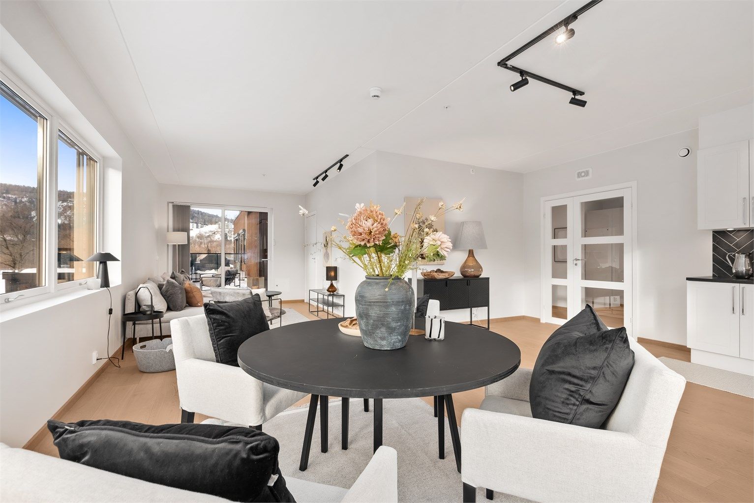 Den åpne løsningen mellom stue, spisestue og kjøkken skaper en sosial atmosfære når man er med venner og familie.