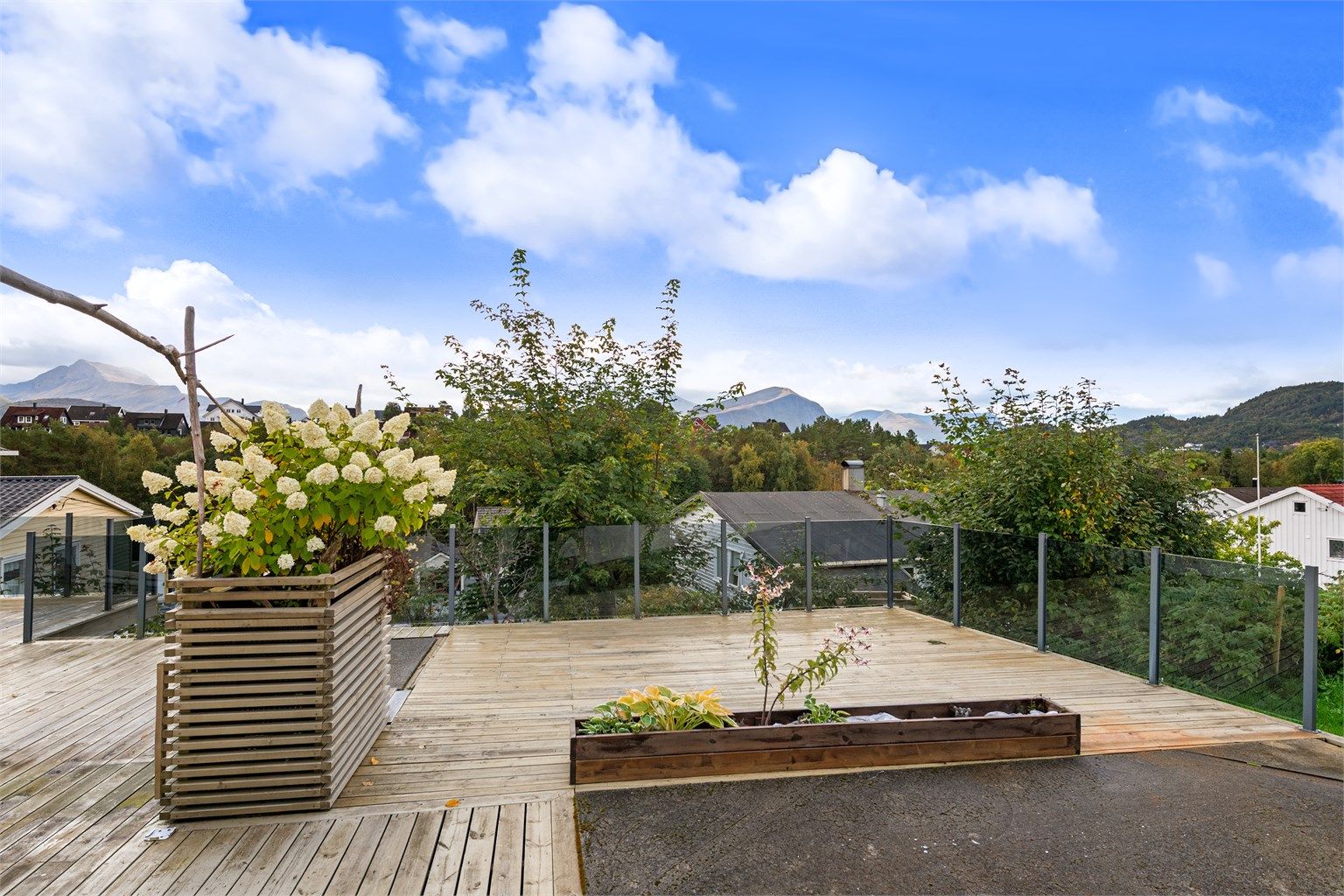Stor terrasse på terreng med glassrekkverk