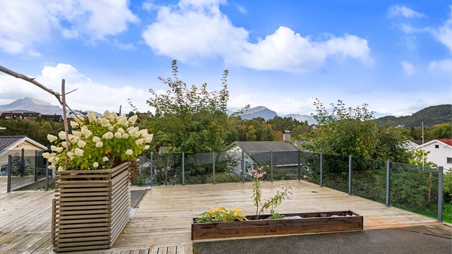 Stor terrasse på terreng med glassrekkverk