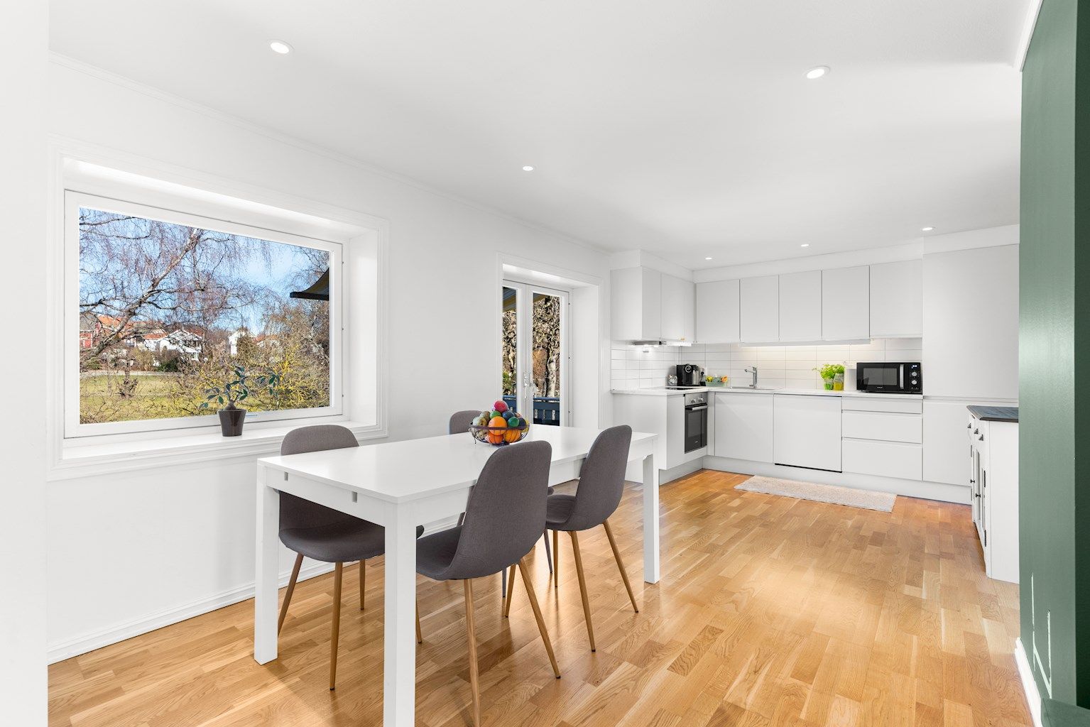 Moderne kjøkkeninnredning med hvite slette fronter og integrerte hvitevarer.