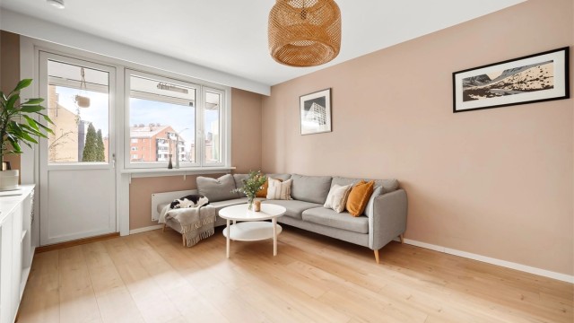 Stuen har en lys og luftig atmosfære med gjennomgående laminatgulv og store vindusflater. Foto: Martine Eren Studio