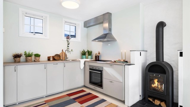 Leiligheten har nytt kjøkken fra IKEA med integrerte hvitevarer, og en peisovn som er koblet til det tidligere bakeriets originale pipe.
Foto: Mats Lie
