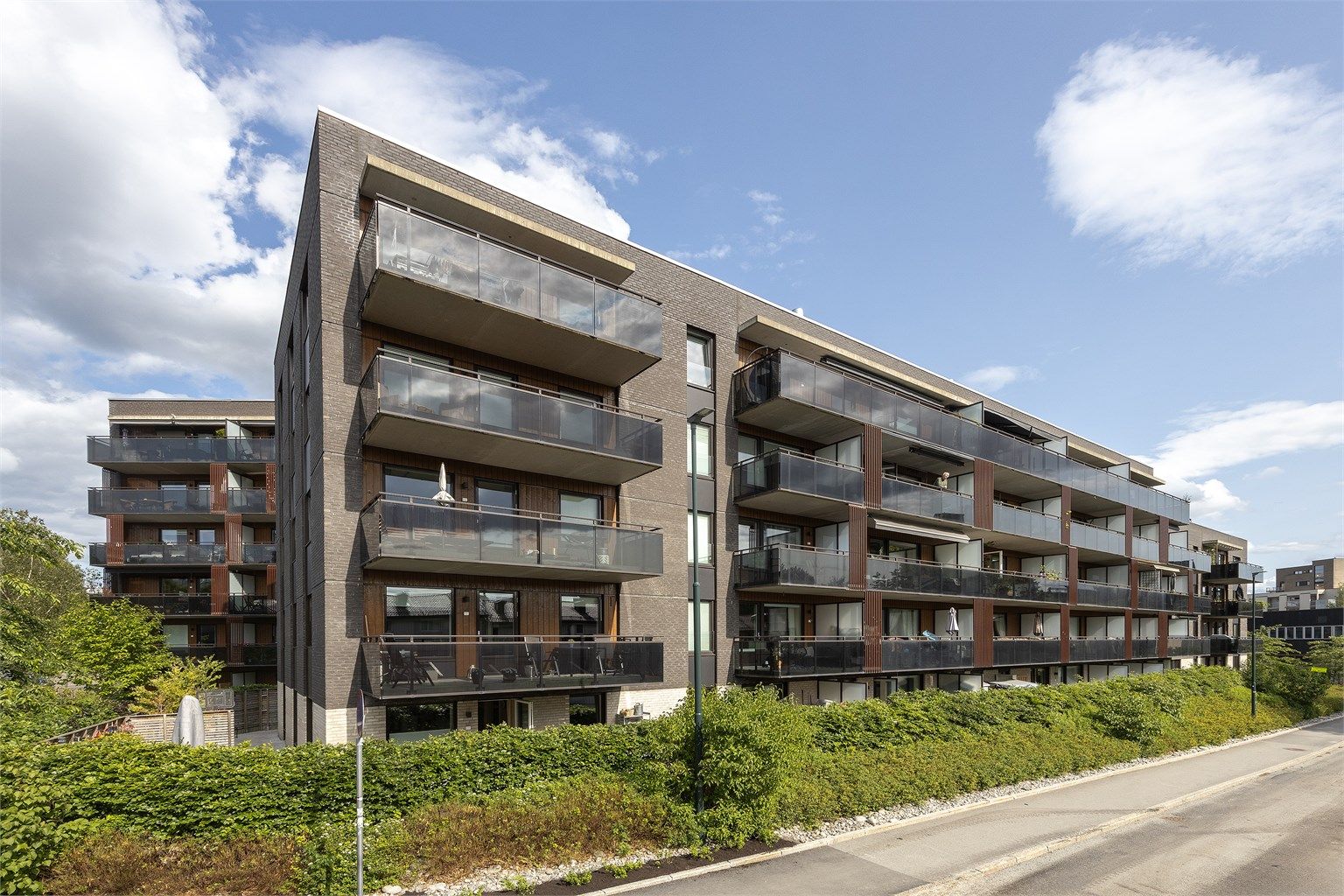 Sydvestvendt fasade som bader i sol store deler av dagen. Sameiet og boligblokken befinner seg i en blindvei uten gjennomgangstrafikk