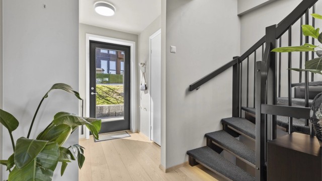 Lys entré med stor integrert skyvedørsgarderobe langs veggen. Fra entreén er det adkomst til toalettrom og et soverom, samt rett inn til stuen.