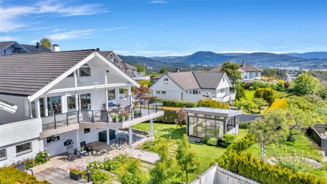 Nydelig eiendom omgitt av grønne omgivelser, blomstrende bed og gode uteplasser som kan nytes gjennom hele året