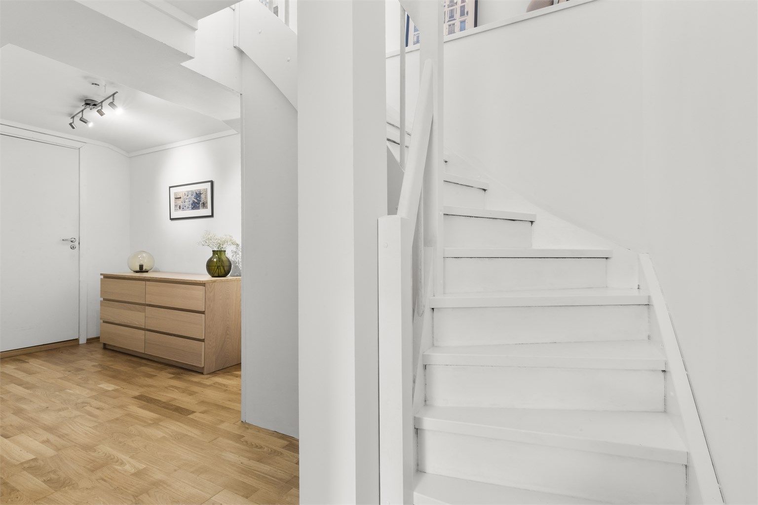 Lyst og romslig trapperom i underetasjen med plass til garderobe/ oppbevaring 