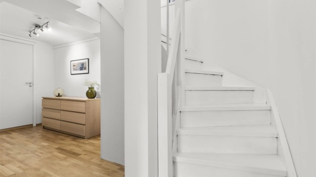 Lyst og romslig trapperom i underetasjen med plass til garderobe/ oppbevaring