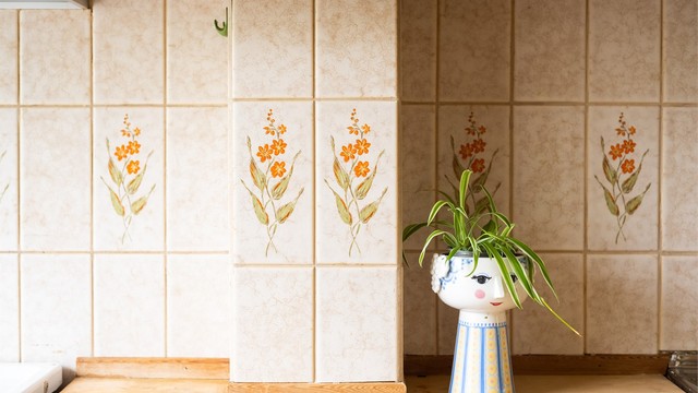 Vegg mellom benkeplate og overskap er flislagt.