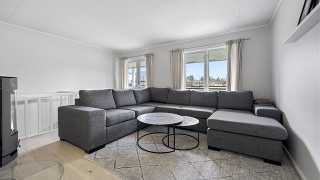 Stuen har plass til en stor sofagruppe og får godt med dagslys fra flere vindusflater.