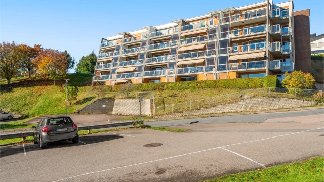 Boligbygget fra 2004 er oppført i teglstein og trepanel med terrasser i skrånende terreng.
