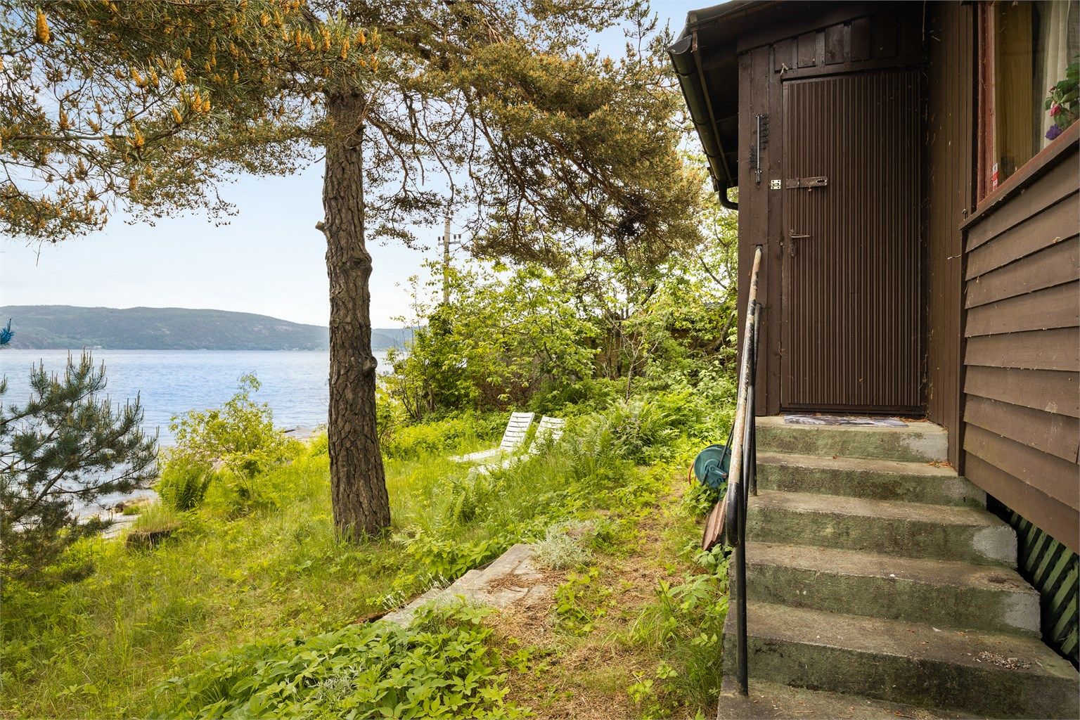 Tomten er opparbeidet med blant annet belegningsstein, gressdekte flater og diverse beplantning. 