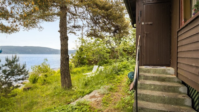 Tomten er opparbeidet med blant annet belegningsstein, gressdekte flater og diverse beplantning.