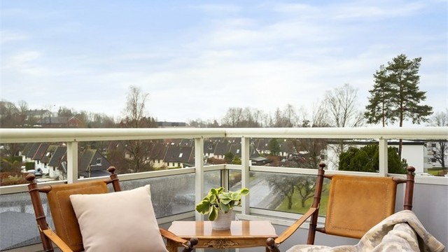 Balkongen har rekkverk av metall og plater, og er utstyrt med markise.