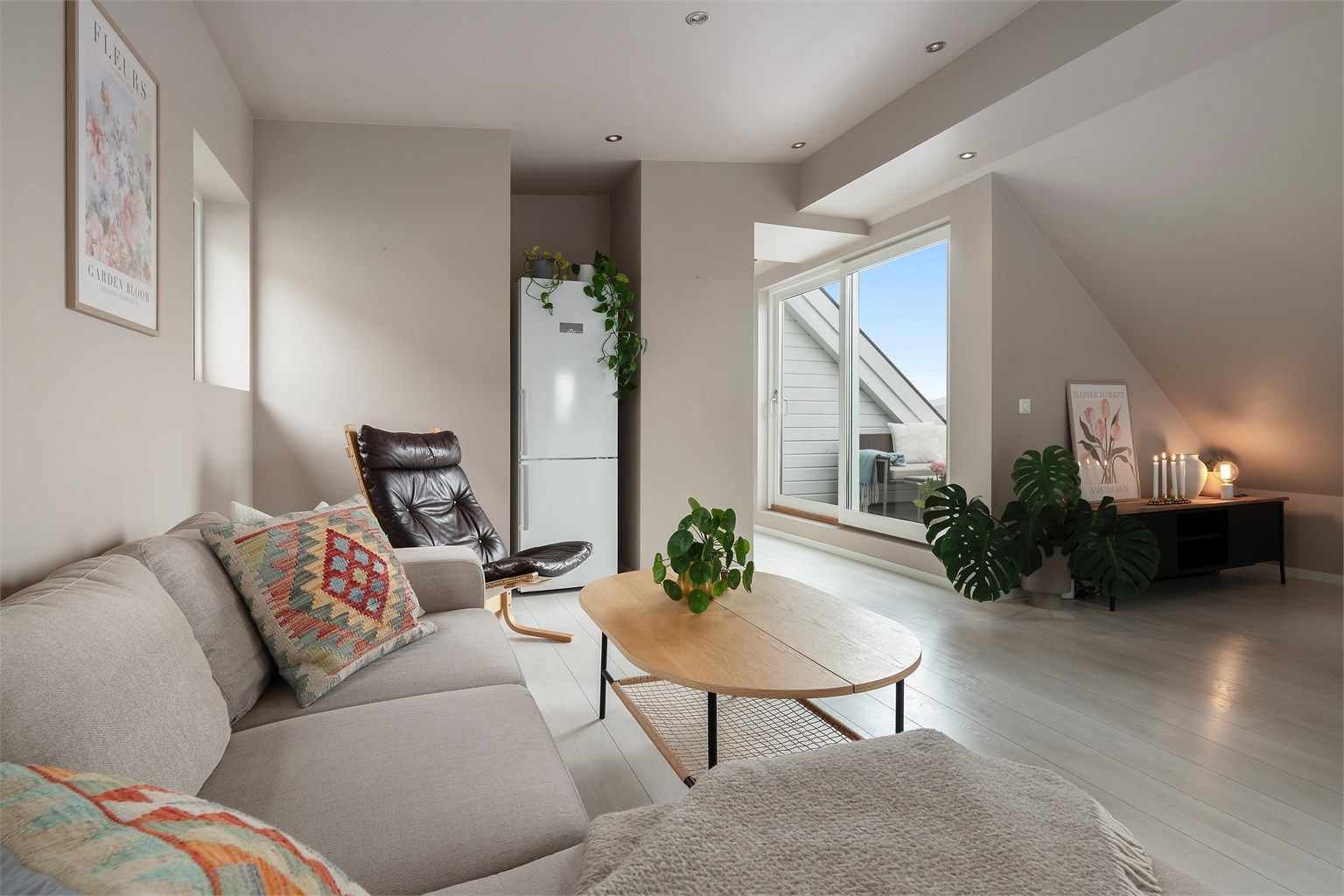 Stuen er malt i en delikat beige/rosa-tone. Legg merke til listefrie overganger og spotlights i taket