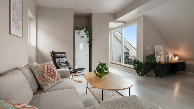 Stuen er malt i en delikat beige/rosa-tone. Legg merke til listefrie overganger og spotlights i taket