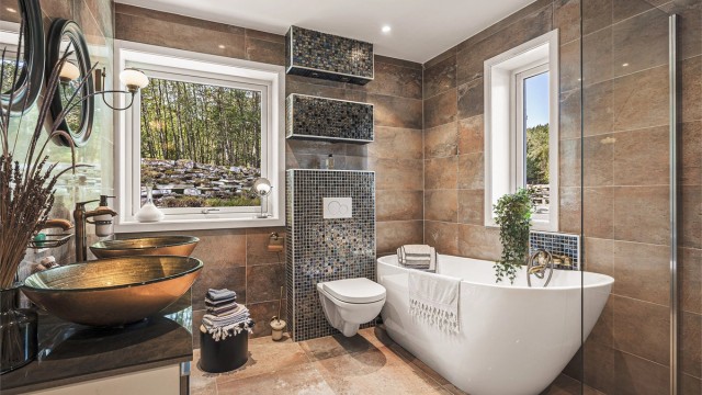 Moderne bad med plass til badekar og dusjhjørne.