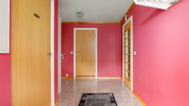 Den romslige entreen er et representativt første møte med boligens indre. Toalettrommet til venstre, badet rett frem.