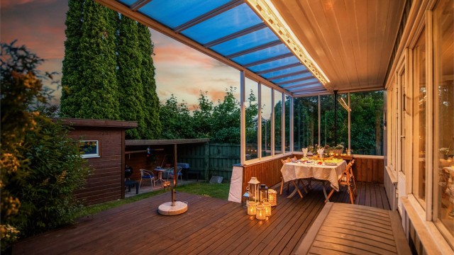 En del av uteplassen er innglasset, slik at du kan sitte lunt og skjermet – perfekt for å nyte lange sommerkvelder, uansett vær og vind.