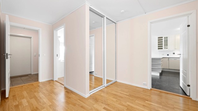 Leiligheten i underetasjen har en egen entré med en stor skyvedørsgarderobe.