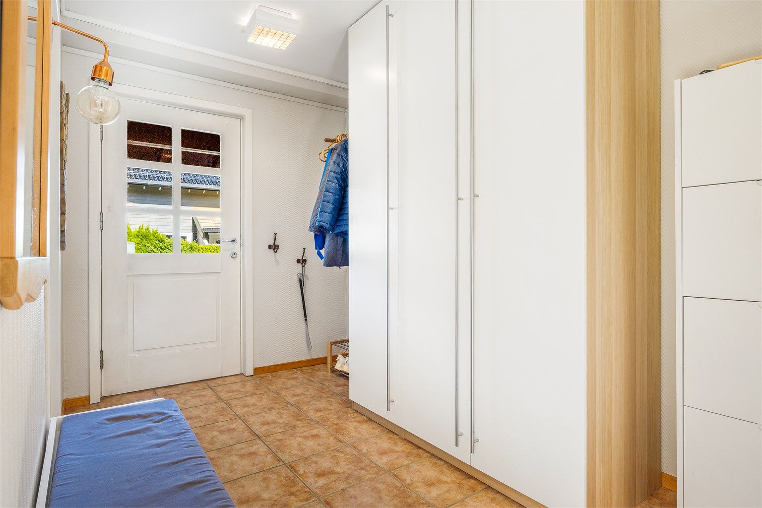 Flislagt entré med gulvvarme og gode oppbevaringsmuligheter i garderobeskap. Entréen leder inn til vaskerom, bad og allrom.