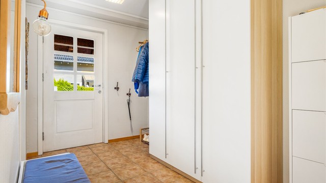 Flislagt entré med gulvvarme og gode oppbevaringsmuligheter i garderobeskap. Entréen leder inn til vaskerom, bad og allrom.