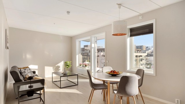 Høyt og lyst i 6. etasje. Store vindusflater fyller stuen med dagslys, og her er det god plass til både sofagruppe og en romslig spisestue for hyggelige middager.