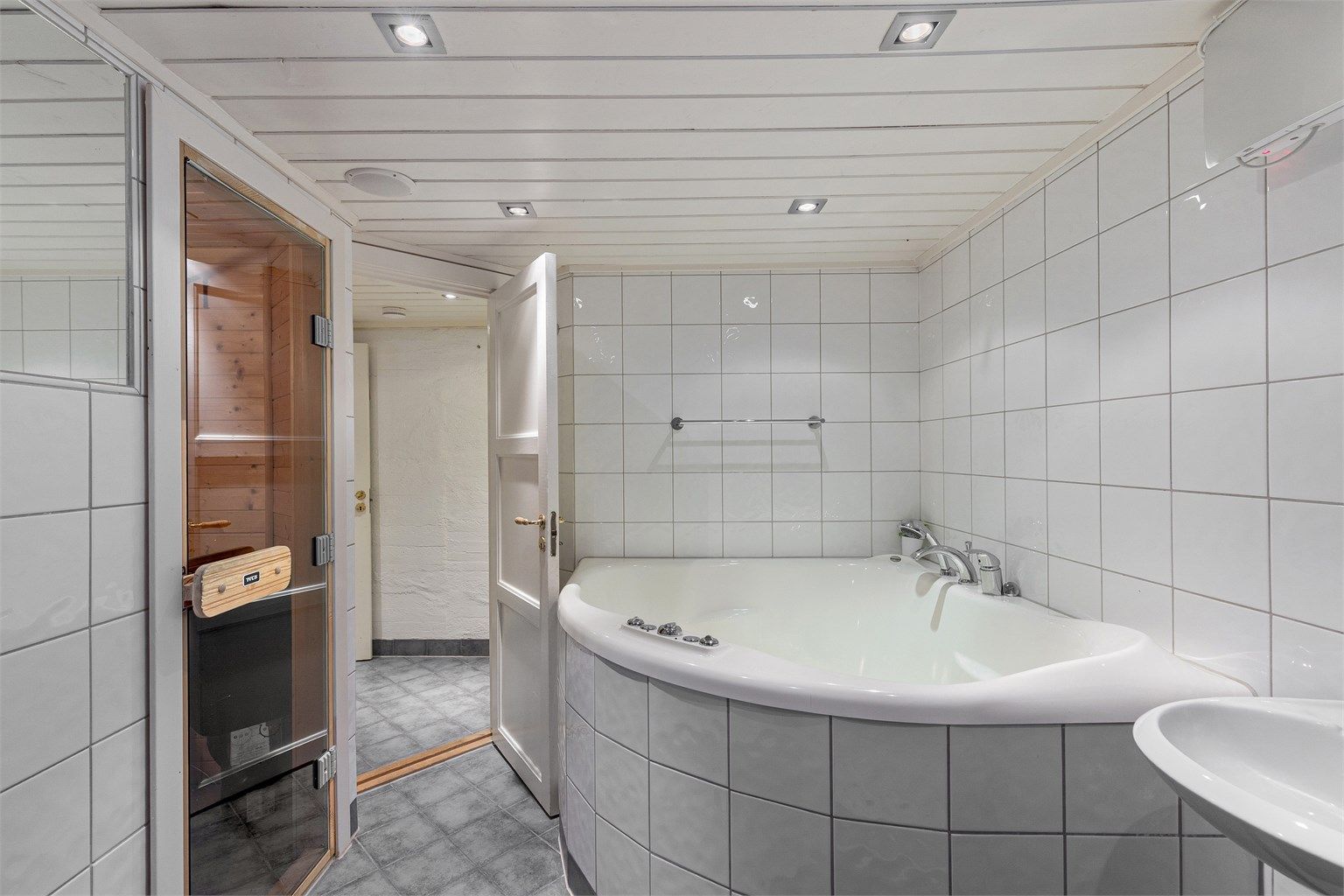 Rommet er innredet med vegghengt toalett, stort spa-badekar, dusjhjørne og servant. Det er også tilgang til en badstue fra badet. Badet er i tilstandsrapport gitt TG3 som en helhetsvurdering. Se rapport for mer info.