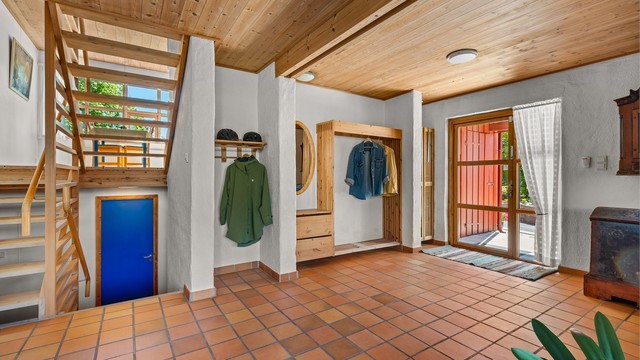 Romslig entré og hall med flislagt gulv og gulvvarme. Herfra er det utgang til en terrasse på 17 m².
